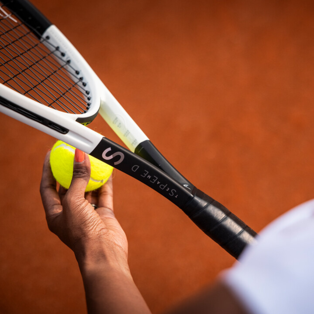 Eine Dame hält den neuen Head Speed Team 2024 Tennisschläger in der rechten Hand. In der linken Hand drückt sie einen Tennisball gegen das Saitenbild des Schlägers.